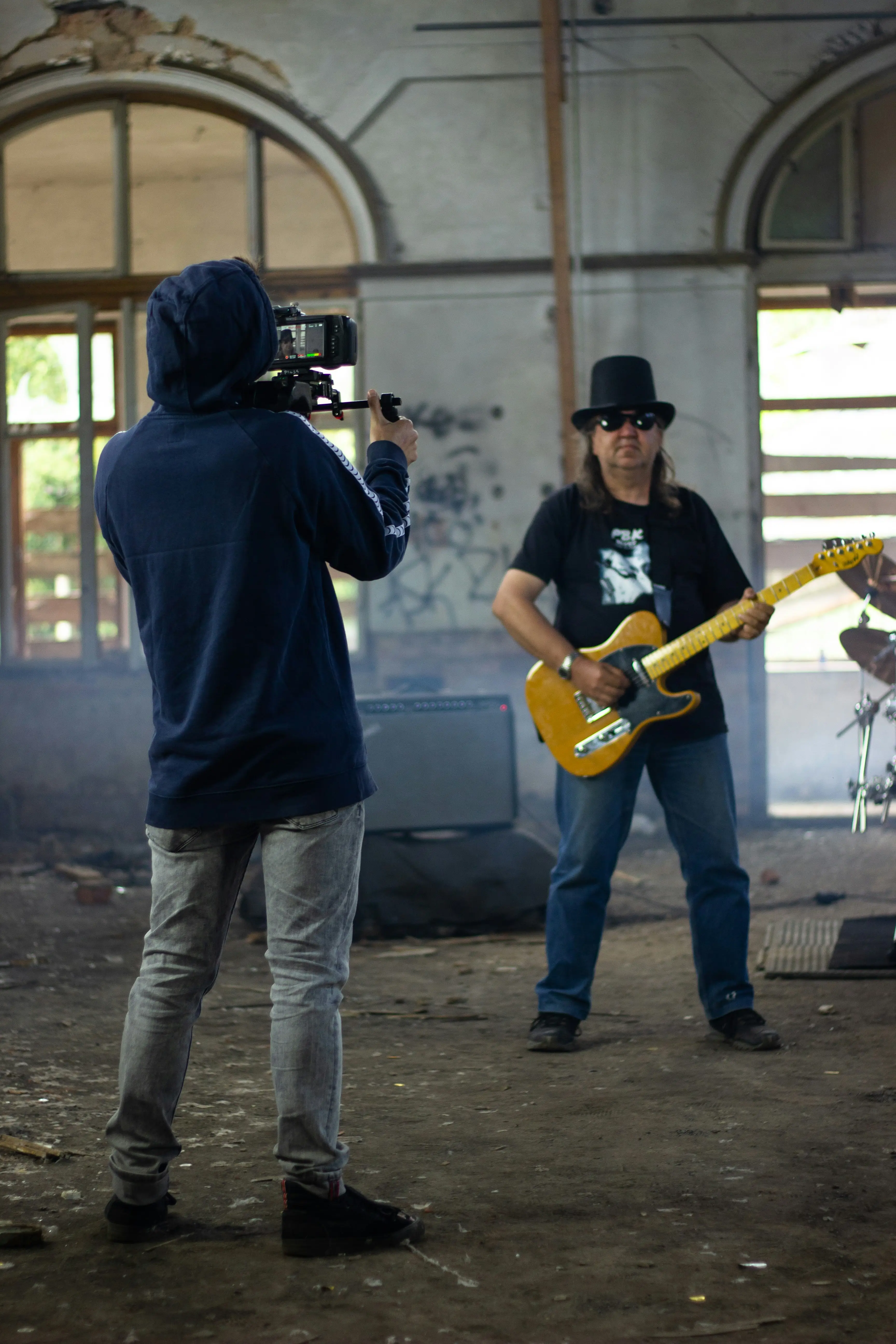 man in blue hoodie playing yellow electric guitar